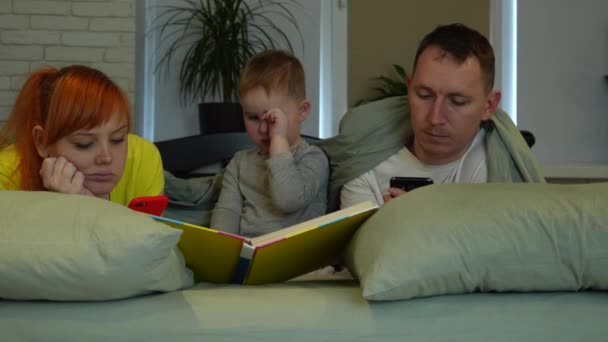 Young Parents Little Boy Bed Mom Dad Look Screens Phones — Vídeos de Stock
