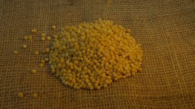 A pile of dry couscous Ptitim groats is poured onto a burlap surface. Close-up. High quality 4k footage