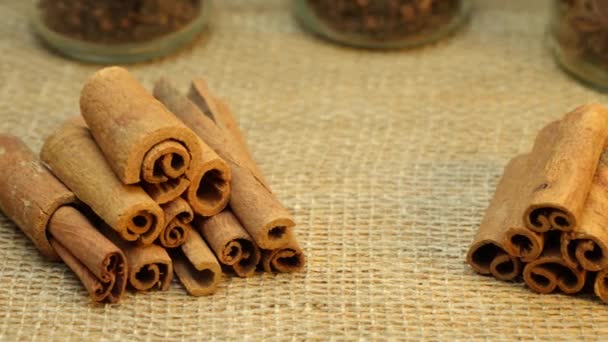 Cinnamon Sticks Stacked Two Piles Surface Covered Burlap Jars Spices — Stock Video