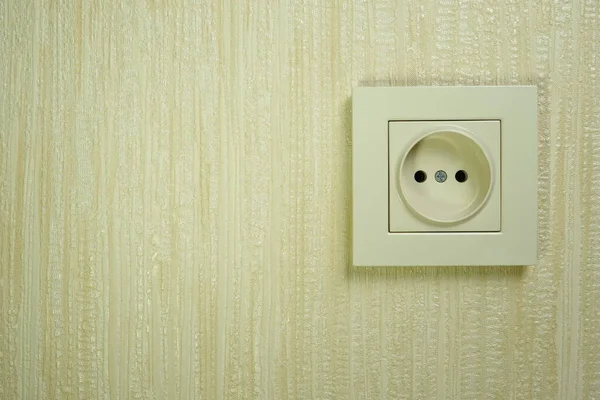 White plastic electrical socket on the wall. Place for text.