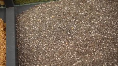 Chia seeds close-up in a black open container on a store counter. Dry healthy ingredient. The concept of proper nutrition. Shot from above.