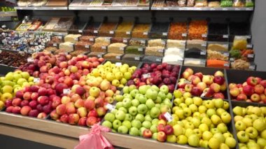 A colorful display with a large assortment of fruits, dried fruits, nuts and grains in an organic food store. Fruits in wooden containers on a shop window.