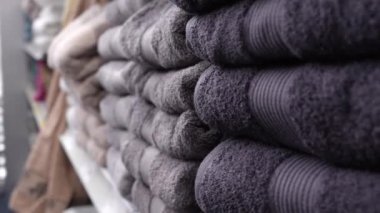 Stacks of neatly folded towels on a store shelf. Terry towels close-up in the store. Sale of interior and design items for the home.