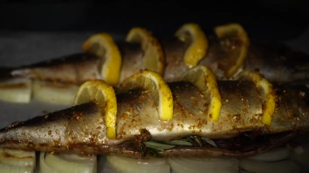 Две Аппетитные Рыбки Лимоном Луковых Кольцах Пергаменте Духовке Крупным Планом — стоковое видео
