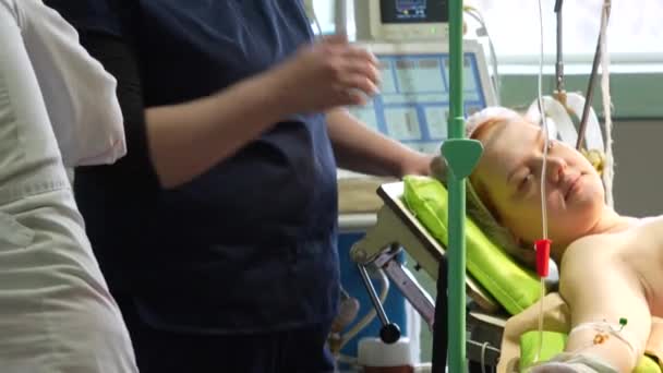 手术台上的小女孩为手术做准备 静脉滴注器连接 剖腹产的过程 高质量的4K镜头 — 图库视频影像