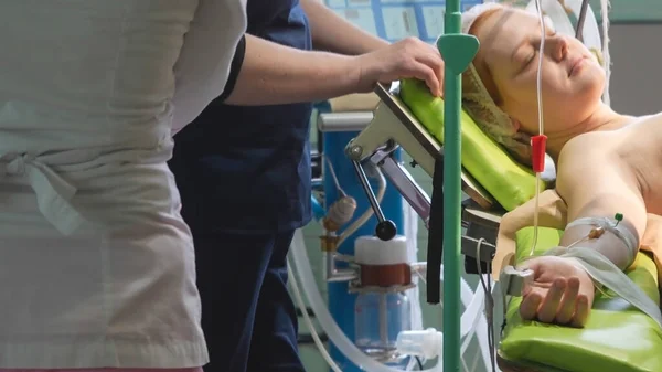 Ameliyat masasındaki genç kız. Ameliyat için hazırlıklar, bir damlatıcıyı damar yoluyla bağlamak. Sezaryen sezaryen işlemi..