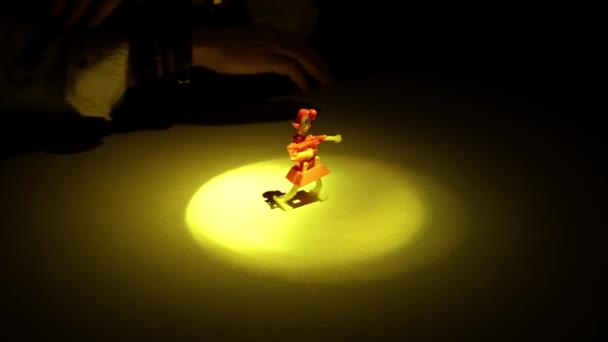 Een Mensenhand Plaatst Een Mechanische Marionet Een Tafel Verlicht Door — Stockvideo