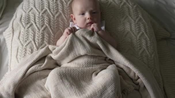 一个3个月大的小男孩躺在毯子下的茧中 自上而下的电线 慢动作 — 图库视频影像