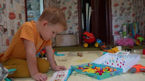 Mały Chłopiec Domu Pokoju Zabaw Dla Dzieci Siedzi Podłodze Patrzy — Wideo stockowe