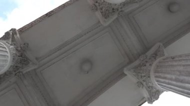 Eski bir binanın eski sütunları. Roma ya da Yunan tarzında güzel bir mimari. Güzel sütunların altından manzarayı seyret. Kameranın dairesel dönüşü. Yüksek kalite 4k görüntü