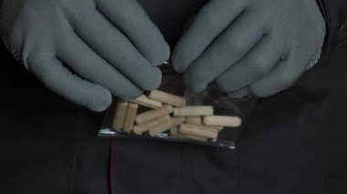 Bir adam ahşap pervazlı şeffaf bir paket açar. Marangozlar iş eldivenlerini yakın plan çekiyorlar. Ağır çekim. Yüksek kalite 4k görüntü