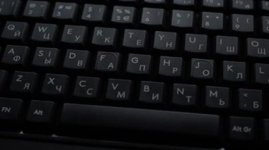 Yakın planlı siyah bilgisayar klavyesi. Kablolar sağa. Ağır çekim. Yüksek kalite 4k görüntü