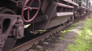 Nakliye treni stoklarına yakın çekim. Çelik yük vagonunun yakın plan çekimleri beton yatakları tıkırdatıyor. Yüklü zıpzıp arabaları hareket ediyor. Yüksek kalite 4k görüntü