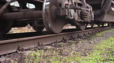 Nakliye treni stoklarına yakın çekim. Çelik yük vagonunun yakın plan çekimleri beton yatakları tıkırdatıyor. Yüklü zıpzıp arabaları hareket ediyor. Yüksek kalite 4k görüntü