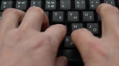 Siyah dizüstü bilgisayar klavyesinde daktilo eden düzgün bir erkek eli. Yakın çekim, üst görüş. Yüksek kalite 4k görüntü