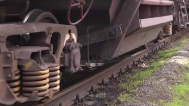 Nakliye treni stoklarına yakın çekim. Çelik yük vagonunun yakın plan çekimleri beton yatakları tıkırdatıyor. Yüklü zıpzıp arabaları hareket ediyor. Yüksek kalite 4k görüntü