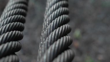 Arka planı bulanık, bükülmüş çelik kabloları kapatın. Yavaş çekim yukarı eğ.