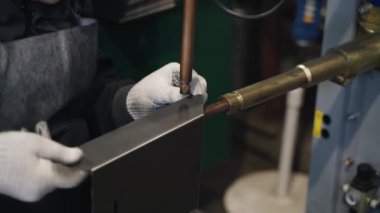 Kalıptaki kaynakçı metal ürünler, metal kutular, kontaksız kaynak makinesi kullanarak evler için posta kutuları yapıyor. Metal ürünlerin üretimi. Toplu üretim, toptan satış.