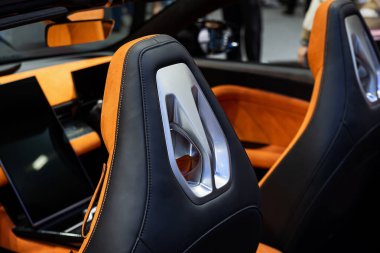 Modern lüks bir arabanın içi. Prestijli modern bir arabanın içi. Turuncu deri koltuklar rahatça oturulabilir. Turuncu delinmiş deri. Modern bir arabanın içindeki detaylar.