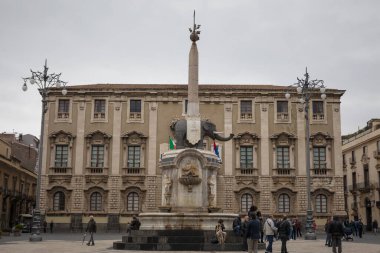 CATANIA, SICILY  - APRIL 22, 2019: The Piazza del Duomo in Catania with people in a day with clouds