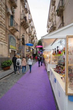 CATANIA, SICILY - APRIL 22, 2019: People visit an open market in a street of Catania, Sicily