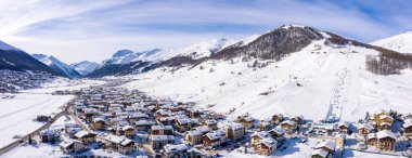 Levigno köyünün havadan görünüşü ve kışın karla kaplı dağların yamaçları. 