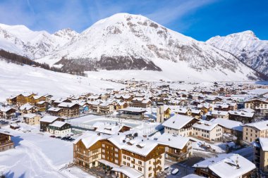 LIVIGNO, İTALYA - 6 Şubat 2020: Aydınlık bir günde karla kaplı Livigno köyünün havadan görünüşü