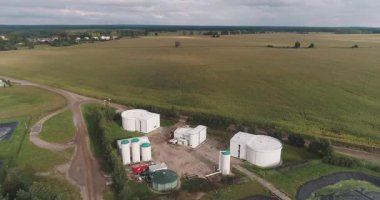 Bir biyogaz fabrikasının havadan yakından çekilmiş panoramik panoramik drone görüntüsü. Tesiste yenilenebilir enerji üretimi ve sürdürülebilir sanayiyi temsil eden büyük depolama tankları, boru hatları ve modern altyapı yer alıyor..