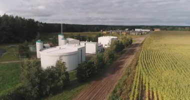 Bir biyogaz fabrikasının havadan yakından çekilmiş panoramik panoramik drone görüntüsü. Tesiste yenilenebilir enerji üretimi ve sürdürülebilir sanayiyi temsil eden büyük depolama tankları, boru hatları ve modern altyapı yer alıyor..