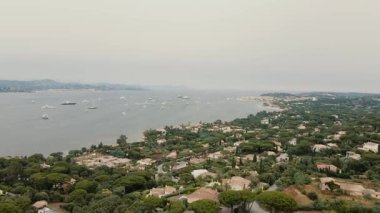 Saint-Tropez, Fransa kıyısındaki lüks villaların yanından geçen teknenin insansız hava aracı çekimi.