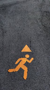 Uyarı üçgeni ile çalışan bir figürü gösteren güvenlik işareti.