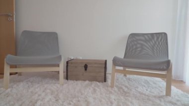 Rahatlamak ve dinlenmek için rahat sandalyeleri olan modern minimalist yatak odası. Bagajlar için çekmeceler. Yüksek kalite 4k görüntü