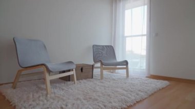 Rahatlamak ve dinlenmek için rahat sandalyeleri olan modern minimalist yatak odası. Bagajlar için çekmeceler. Yüksek kalite 4k görüntü