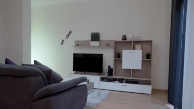 Oturma odası, kanepe, televizyon, modern dekorasyon, loş ışık. Hareket halindeyken çekiyoruz. Yüksek kalite 4k görüntü