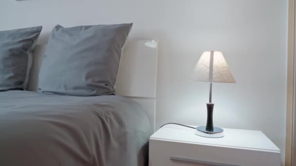 现代简约的卧室 用于休息和睡眠 床头柜上的简约灯具 高质量的4K镜头 — 图库视频影像