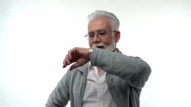 Sakallı ve gözlüklü yaşlı bir emekli saati izliyor. Yalnızlık kavramı. Yüksek kaliteli FullHD görüntüler