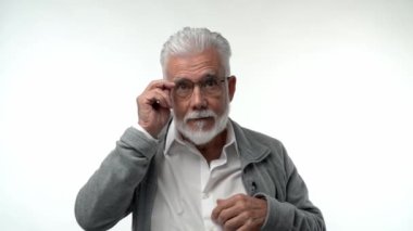 Yaşlı bir adam gözlük takar ve farklı duyguları şaşkınlıkla ifade eder. Yaşla ilgili görme sorunu kavramı. Yüksek kaliteli FullHD görüntüler