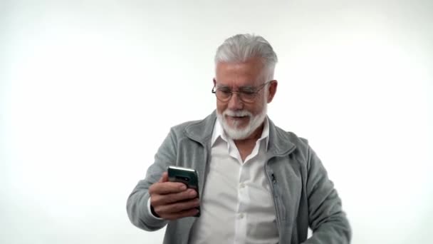 Homem Idoso Com Barba Olha Alegra Com Smartphone Gesticulando Com — Vídeo de Stock