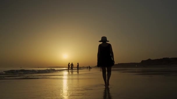 Sahilde Gün Batımı Bir Kadın Okyanus Boyunca Yürür Dalgalar Kıyıya — Stok video