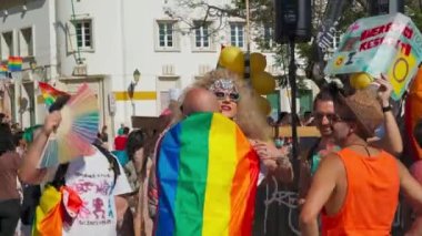 LGBT onur yürüyüşü, geleneksel olmayan yönelimli insanları desteklemek, LGBT topluluğunun bayrakları, eski dostlarla tanışmak. Portekiz, Faro, 25 Haziran 2022 Rua Santo Antonio Baixa Faro