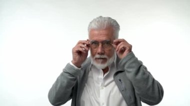 Yaşlı bir adam gözlük takar ve farklı duyguları şaşkınlıkla ifade eder. Yaşla ilgili görme sorunu kavramı. Yüksek kaliteli FullHD görüntüler