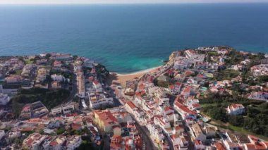 Sahil kenti Carvoeiro 'nun uçurum plajları ve geleneksel Portekiz evleri ile güzel hava manzarası. Yüksek kalite 4k görüntü