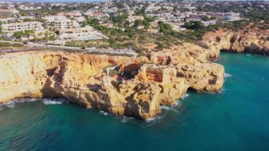 Sahil kenti Carvoeiro 'nun uçurum plajları ve geleneksel Portekiz evleri ile güzel hava manzarası. Yüksek kalite 4k görüntü