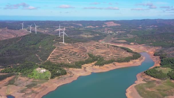 空中展望 ダムとブラヴラ貯水池の上の無人機によるビデオ撮影 南部の水供給の低レベルと雨の欠如 背景に風力発電機 高品質4K映像 — ストック動画