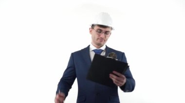 Takım elbiseli ve kasketli genç bir mühendis, projeler için önemli planlama notları veya yapılacaklar listesi hazırlar. Çalışanlar ve mühendisler konsepti