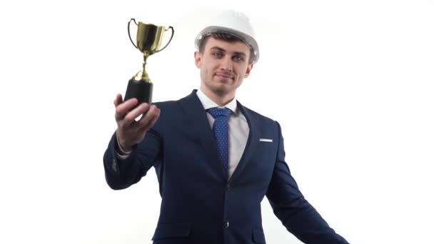 スーツ ネクタイ ハード帽子のビジネスマンは 彼の手の中に最初の勝者として賞カップを示しています ビジネスと生活の中で大きな成功の概念 白い背景で 高品質のフルHd映像 — ストック動画