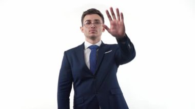 A man businessman in a suit and glasses on a white background shows an emotional gesture with his hand about the prohibition. High quality FullHD footage