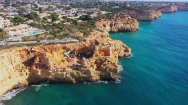 Sahil kenti Carvoeiro 'nun uçurum plajları ve geleneksel Portekiz evleri ile güzel hava manzarası. Yüksek kalite 4k görüntü