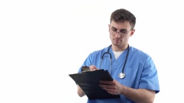 A young doctor in uniform and with a stethoscope writes annotations in a notebook. The concept of development of young professionals in world medicine