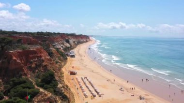 Amazing aerial sea view of Portuguese beaches with vacationing tourists and nature. Falesia beach. Drone camera movement forward. High quality 4k footage